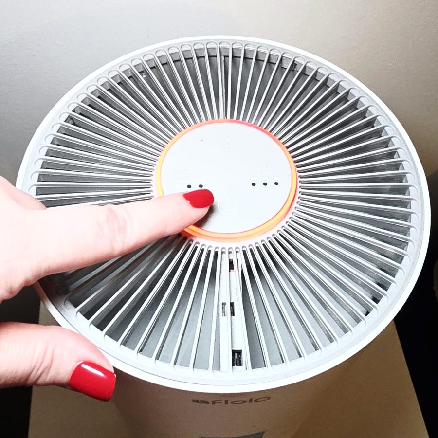 Top view of the purifier with the red ring lit, my finger on the button