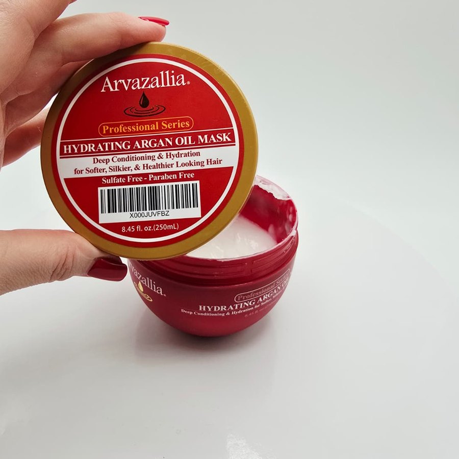 Holding the lid of my Arvazallia Hydrating Argan Oil Mask above the open jar with the white cream inside