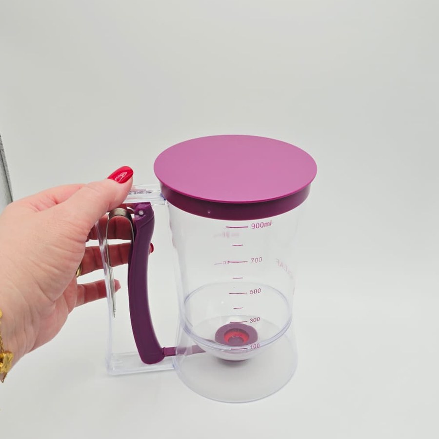 My hand holding the handle of my purple batter dispenser