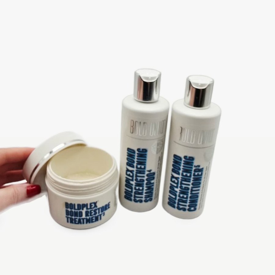 The Boldplex Bond Restore Treatment jar open, showing the cream, with the shampoo and conditioner behind