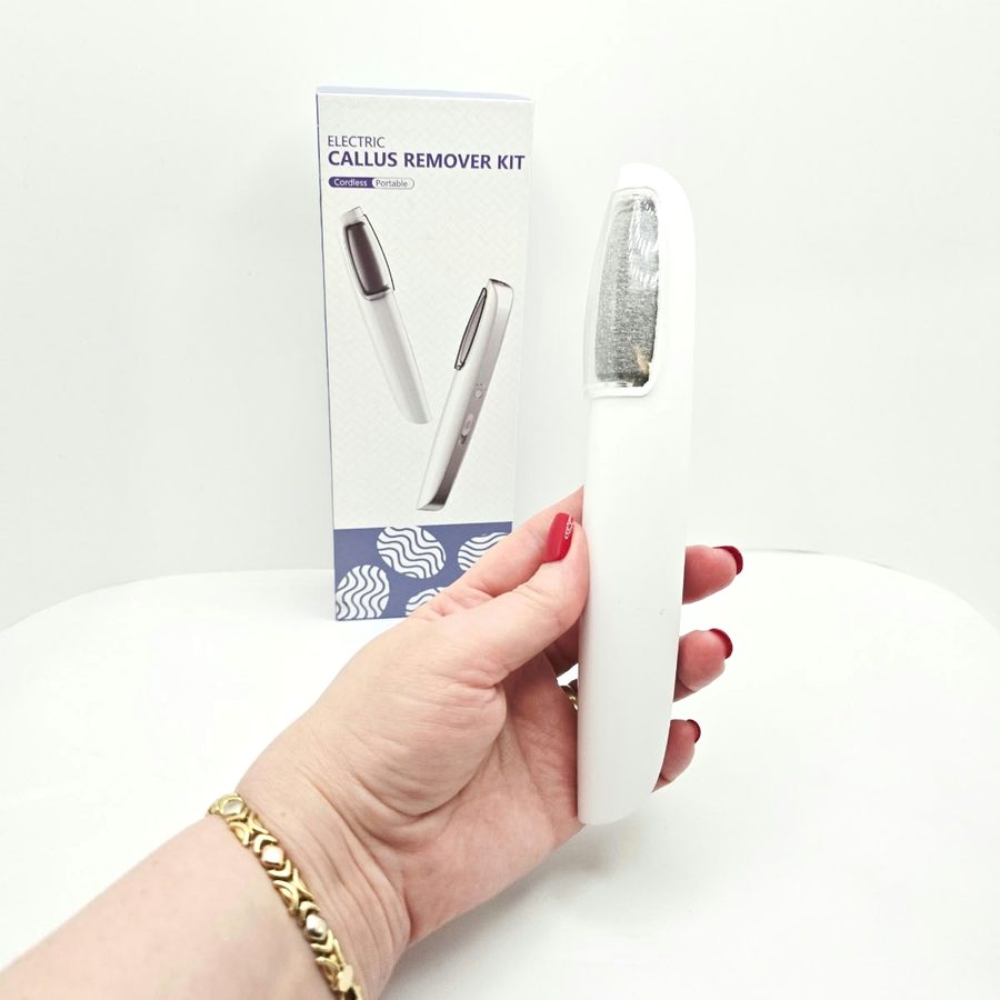 My hand holding the white LINKEVAP callus remover in front of its box