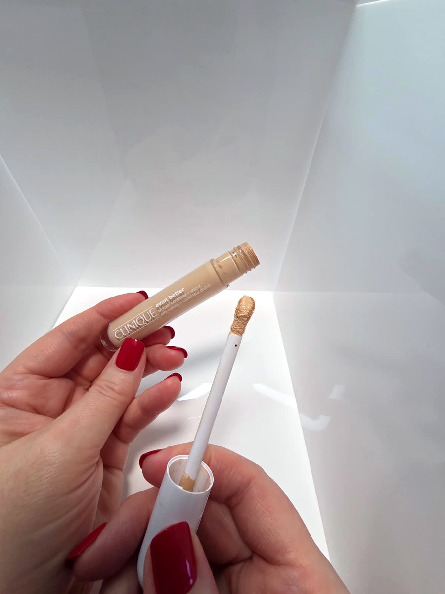 Holding the Clinique concealer and its sponge applicator