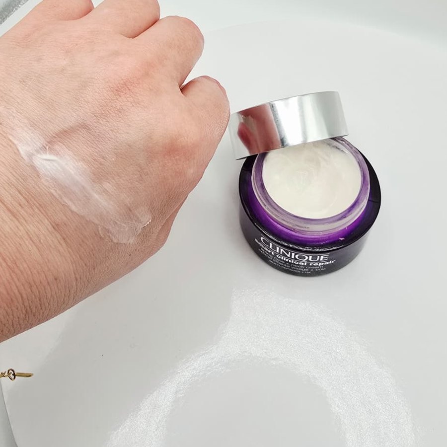 A swipe of Clinique Smart Clinical Repair cream on the back of my hand, with the open jar beside it