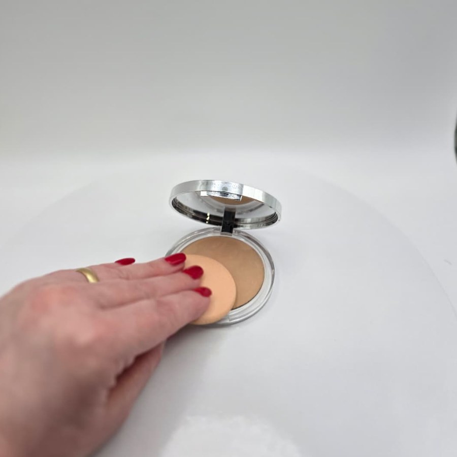 My hand pressing the sponge into my Clinique Stay-Matte powder