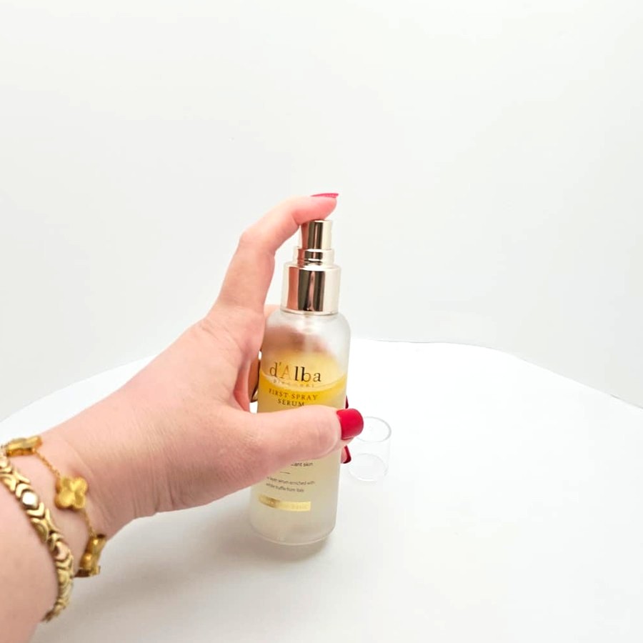 My finger pressing the pump of the d'Alba spray serum