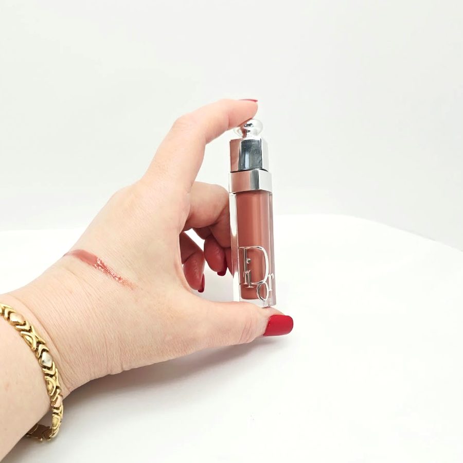 My hand holding the Dior gloss, with a swatch on my hand
