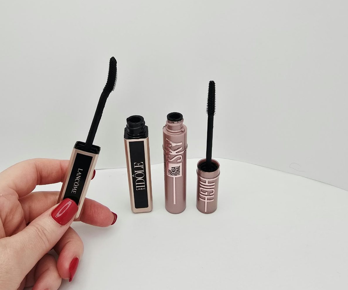 My two mascaras, open on my counter: Lancôme Lash Idôle with its curved brush in my hand, and Maybelline Sky High with its thin, flexible brush