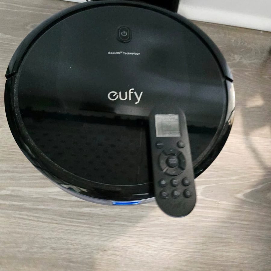 The remote control of my eufy RoboVac 11S MAX resting on top of the vacuum