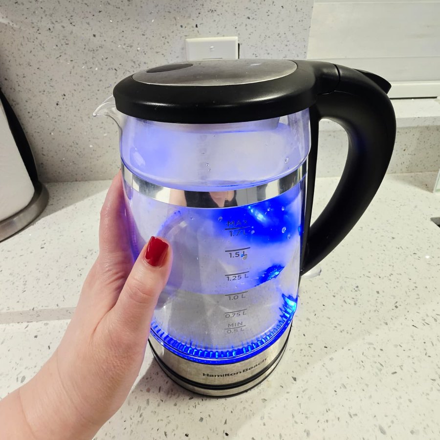 My hand on the Hamilton Beach kettle glowing blue while the water heats