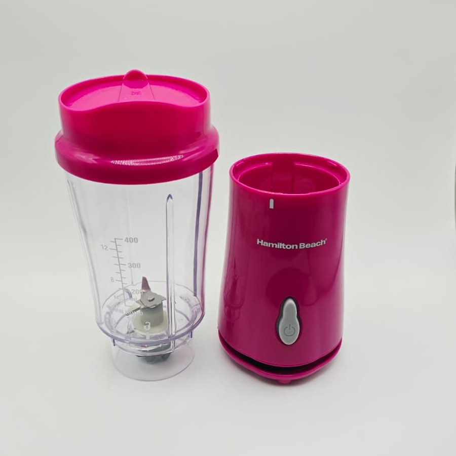 My raspberry Hamilton Beach personal blender taken apart: the clear 14 oz jar with its lid next to the pink base