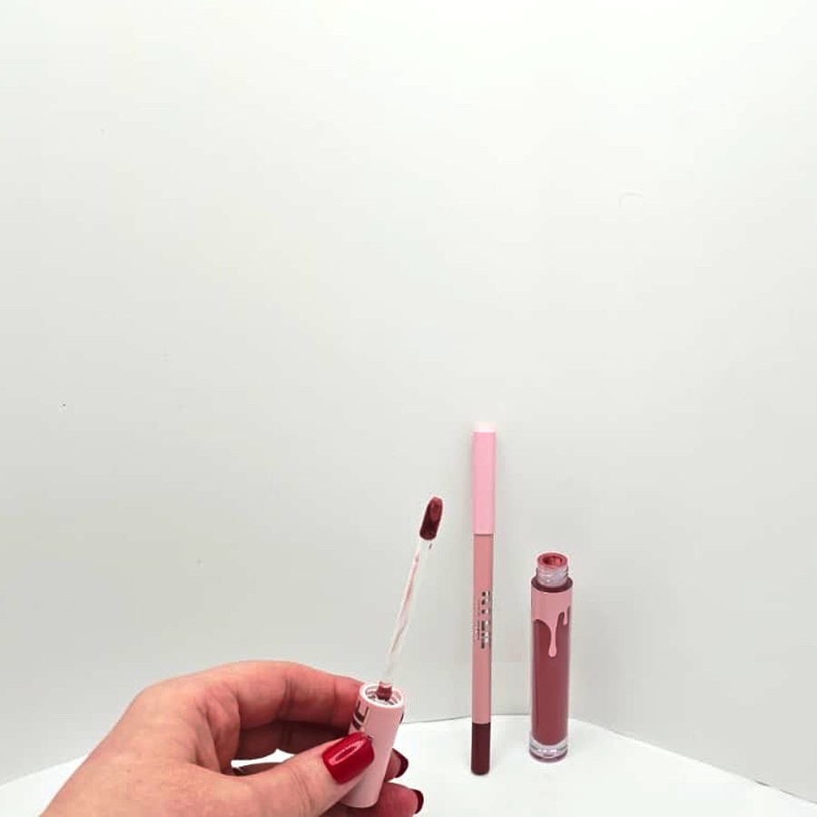 My hand holding the doe-foot applicator of the Kylie liquid lipstick