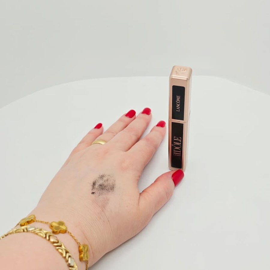 A swatch of my Lancôme Lash Idôle mascara on the back of my hand, next to the closed tube