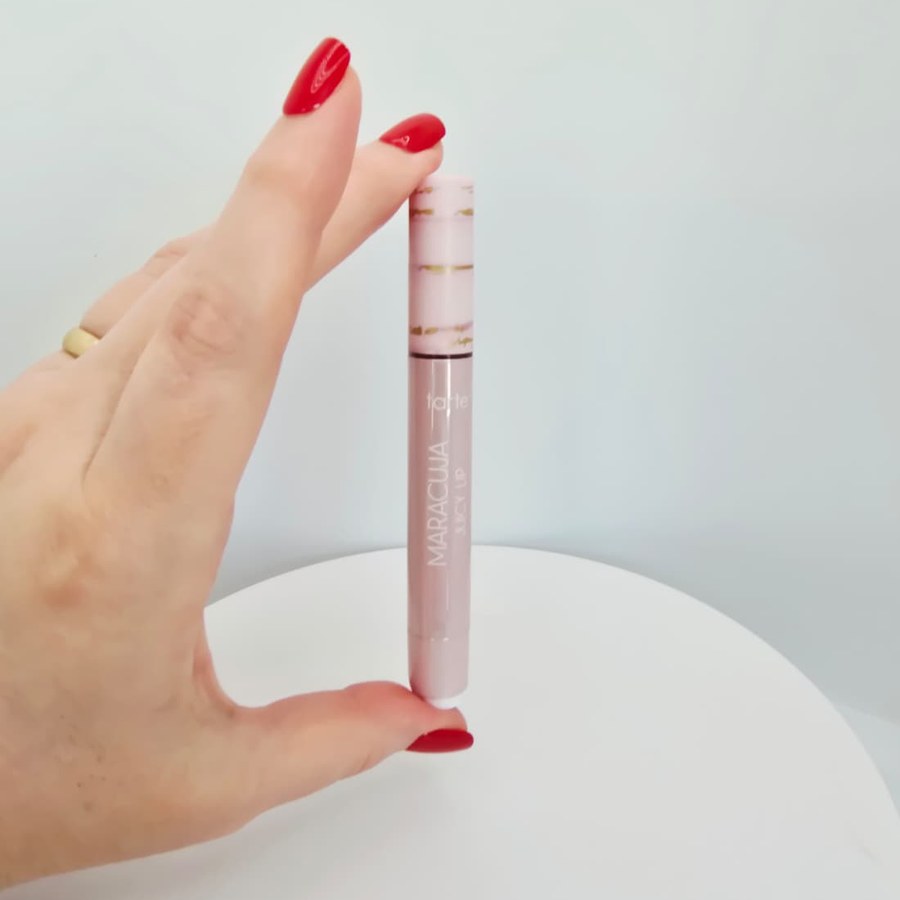 My tarte Maracuja Juicy Lip held between two fingers