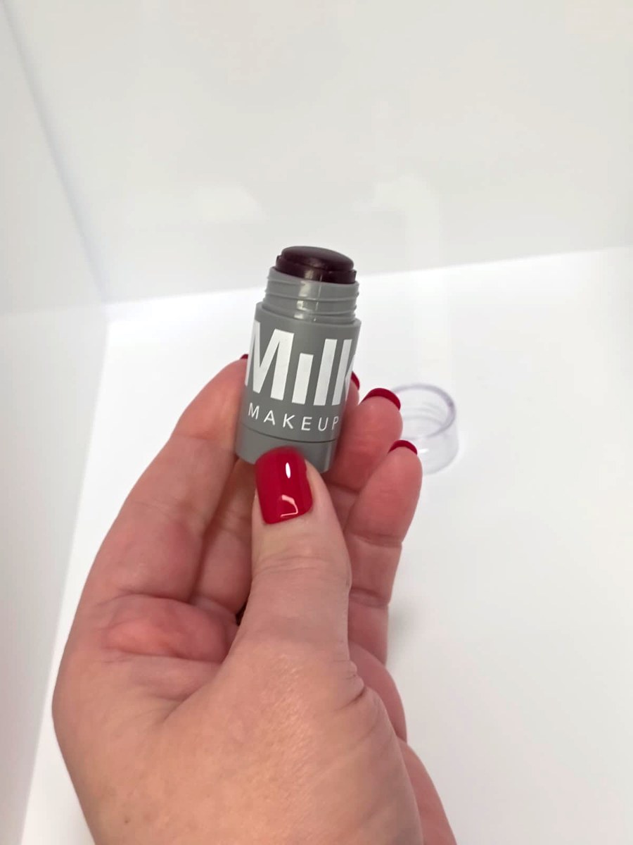 Holding the Milk Makeup Muse stick with the cap off
