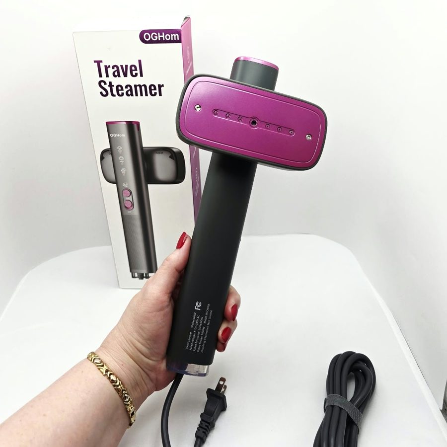 My hand holding the steamer with the pink steam plate facing forward