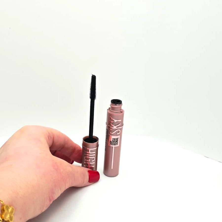 My hand opening the Maybelline Sky High mascara next to the tube