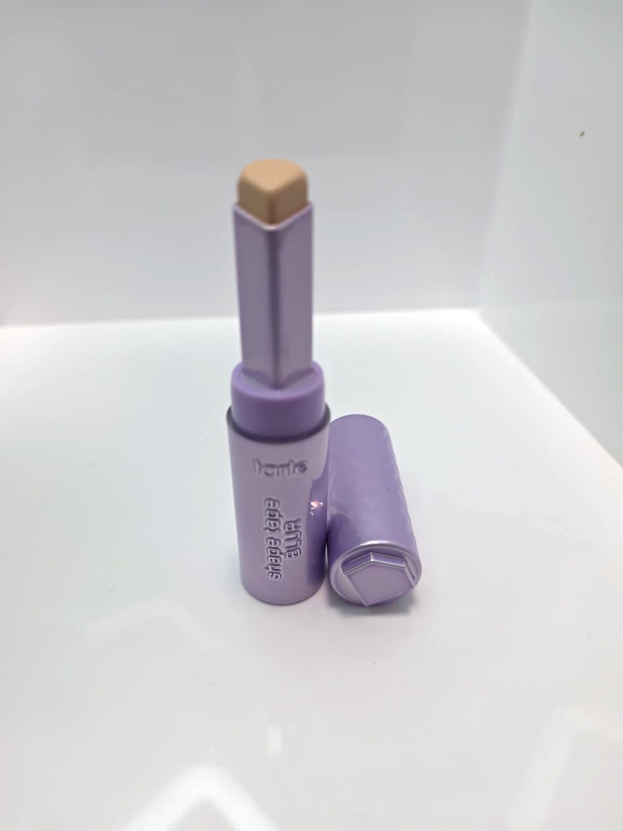 The Tarte Shape Tape Blur concealer stick uncapped next to its lavender cap
