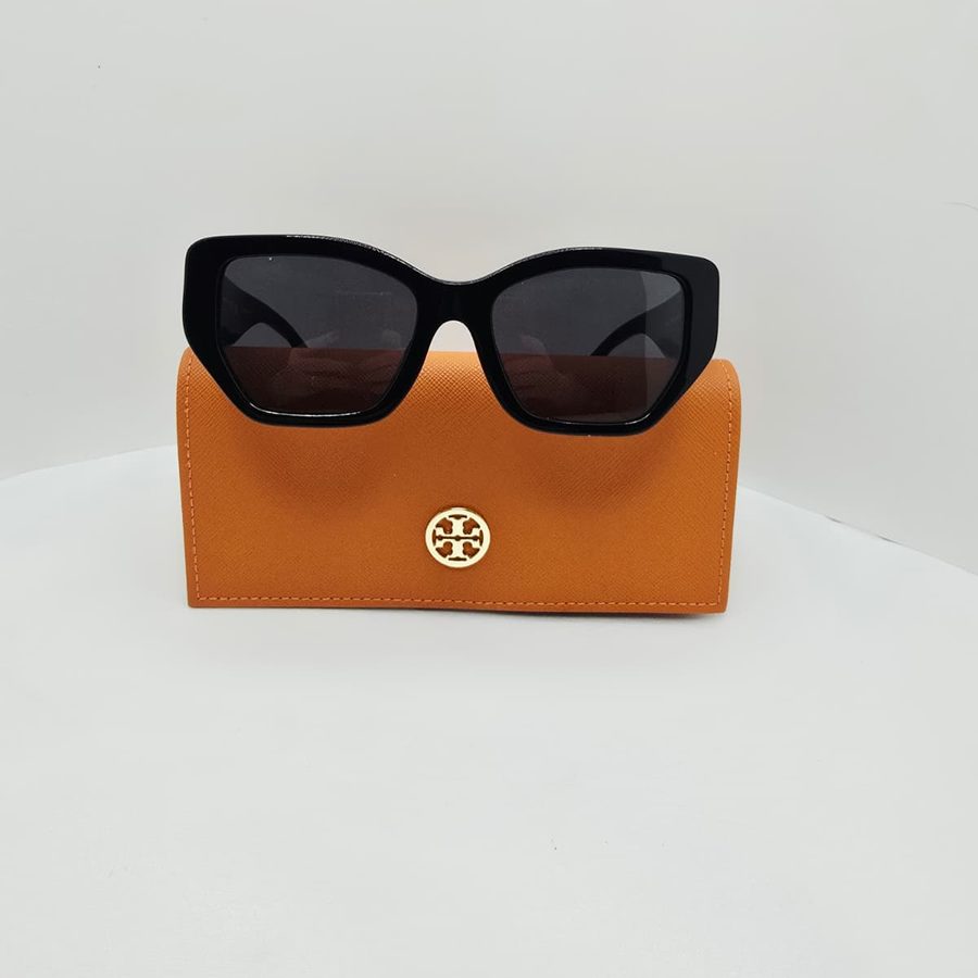 My black Tory Burch Kira sunglasses resting on their orange Tory Burch case