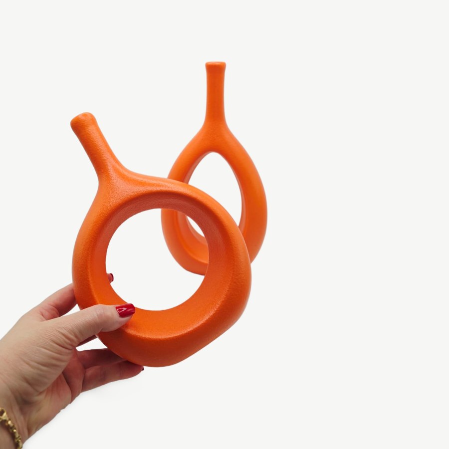 Holding the small orange XMGZQ ceramic vase, with the tall one behind it